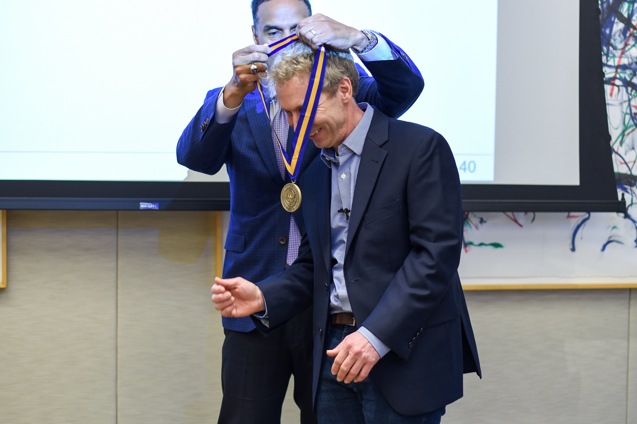 Dean Gallimore presents the ceremonial professorship medal to Prof. Blaauw.